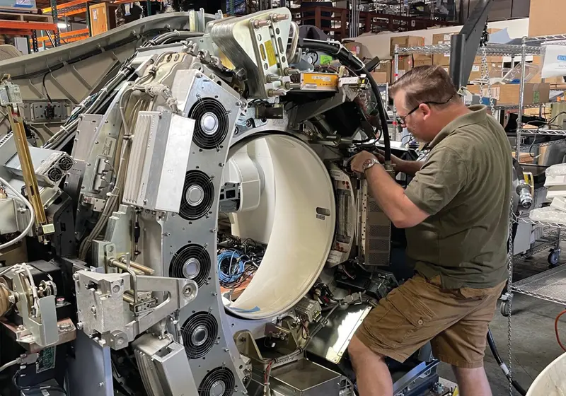 An EverX engineer working inside a CT gantry